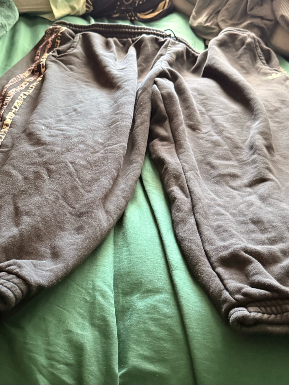 Women’s black Adidas sweatpants with cheetah stripes